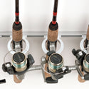 Close up of a custom fishing rod rack holder holding spinning reels.